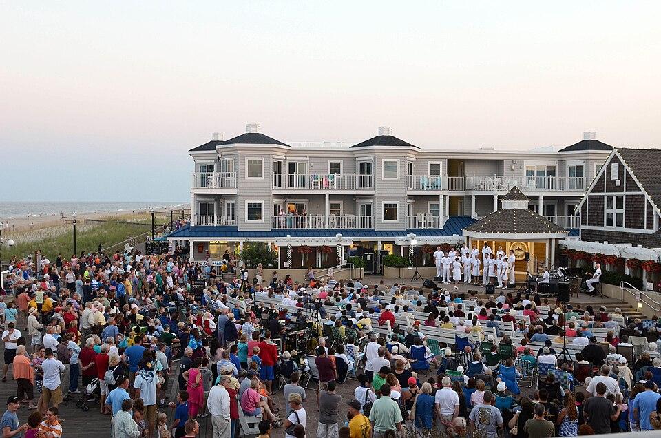 The Bethany Beach Bandstand at dusk with a crowd gathered for a concert